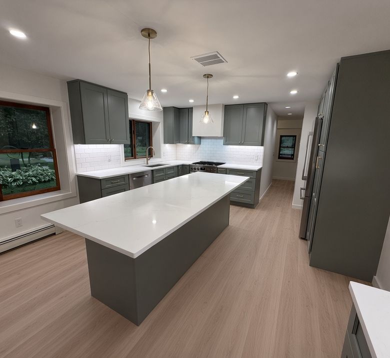 Quartz island and perimeter tops in a soft sage kitchen