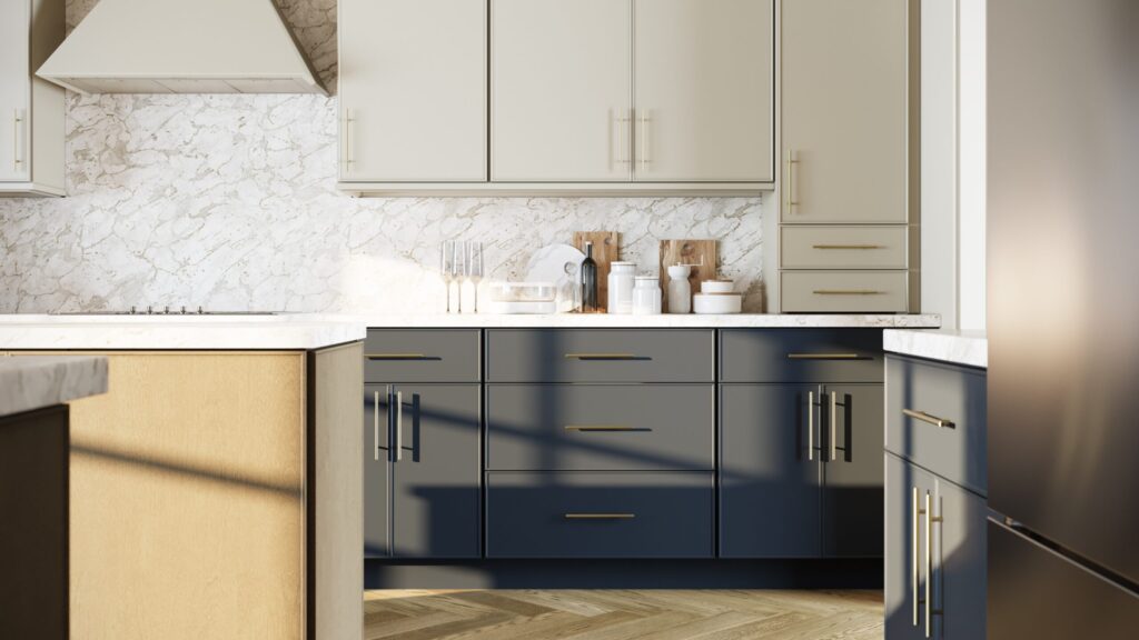 Kitchen detail with cream upper cabinets, navy lower cabinets, marble backsplash and brass hardware